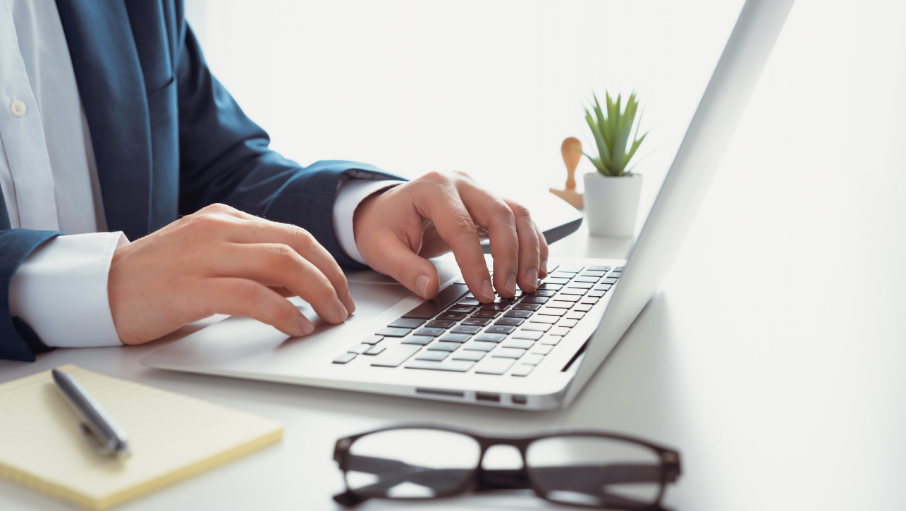 Man in kantooromgeving aan het werk met laptop.