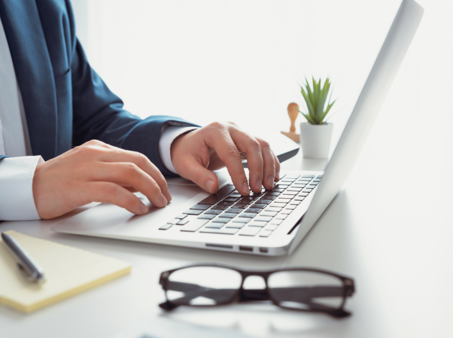 Man in kantooromgeving aan het werk met laptop.