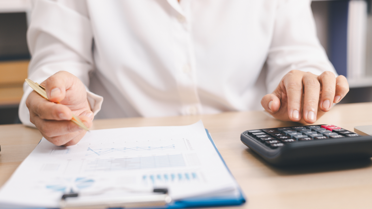 Ondernemer aan bureau met laptop en belastingdocumenten, bezig met de administratie van S&O-uren voor de WBSO-regeling.