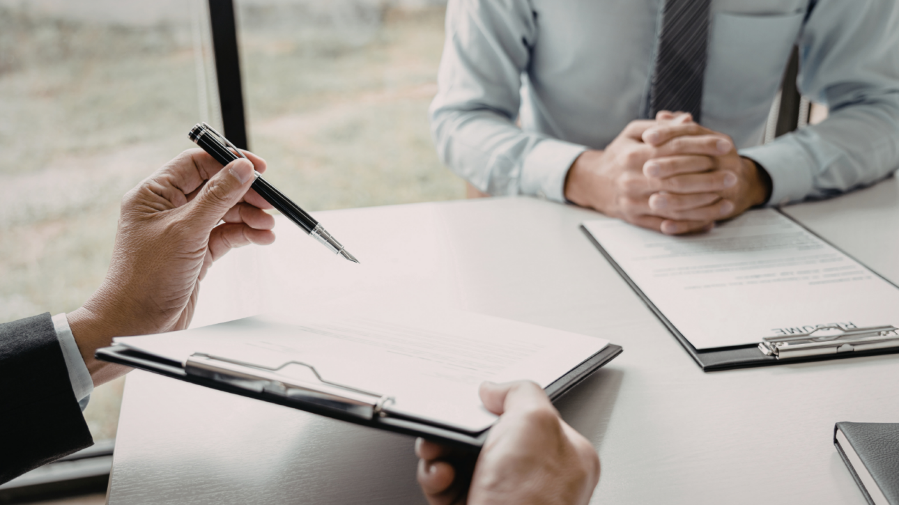 Ondertekening van zakelijk document aan vergadertafel, als illustratie van de meldplicht bij wijzigingen in een fiscale eenheid voor de btw