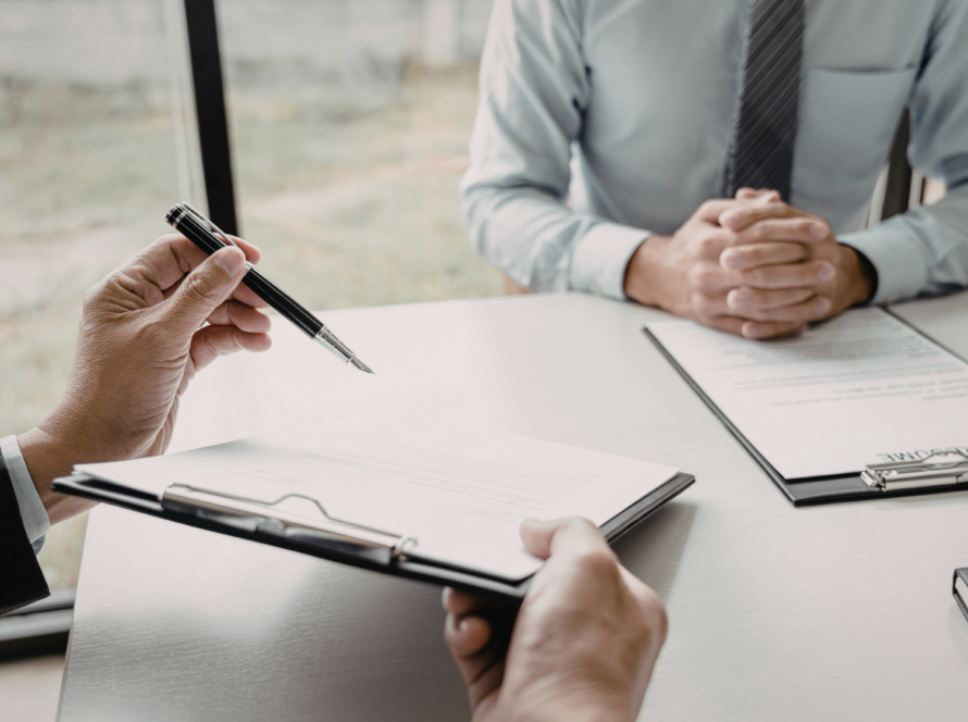 Ondertekening van zakelijk document aan vergadertafel, als illustratie van de meldplicht bij wijzigingen in een fiscale eenheid voor de btw
