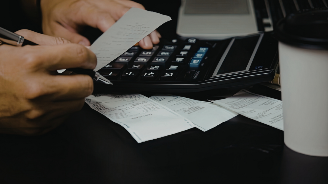 Calculator met bonnetjes en facturen als illustratie van zakelijke kostenaftrek voor ondernemers