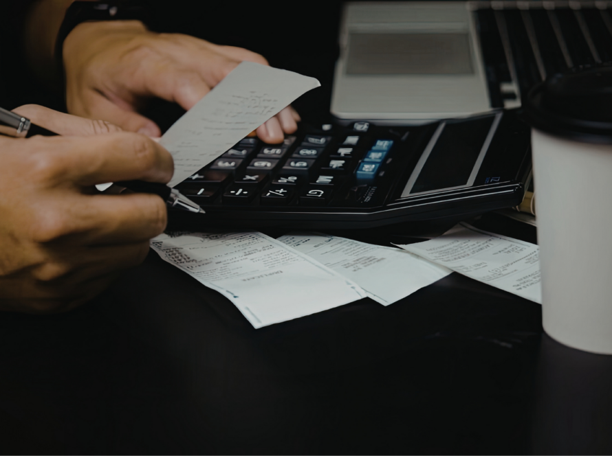 Calculator met bonnetjes en facturen als illustratie van zakelijke kostenaftrek voor ondernemers