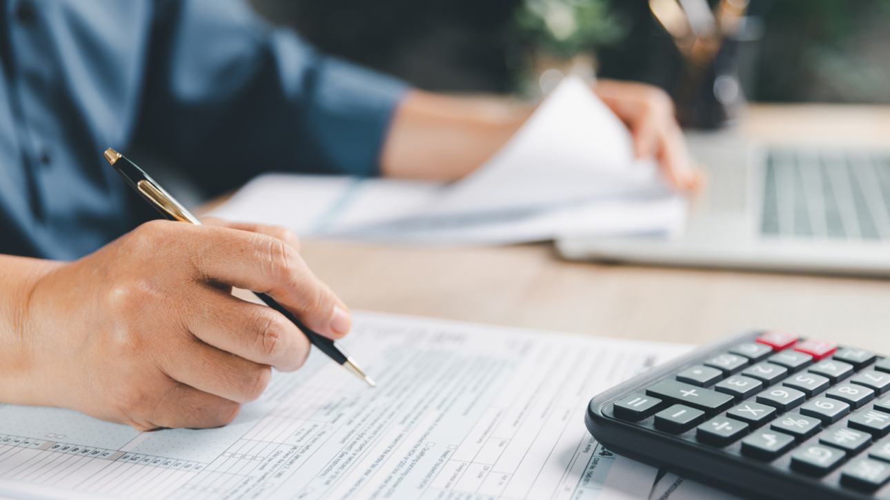 Ondernemer vult btw-aangifte in achter bureau met facturen en calculator als illustratie van veelgemaakte fouten in de btw-aangifte