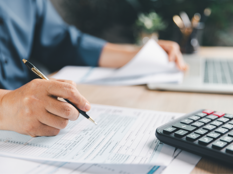 Ondernemer vult btw-aangifte in achter bureau met facturen en calculator als illustratie van veelgemaakte fouten in de btw-aangifte